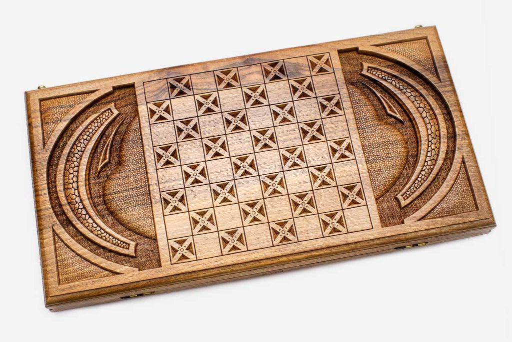 Angled view of the mask master carved walnut backgammon board