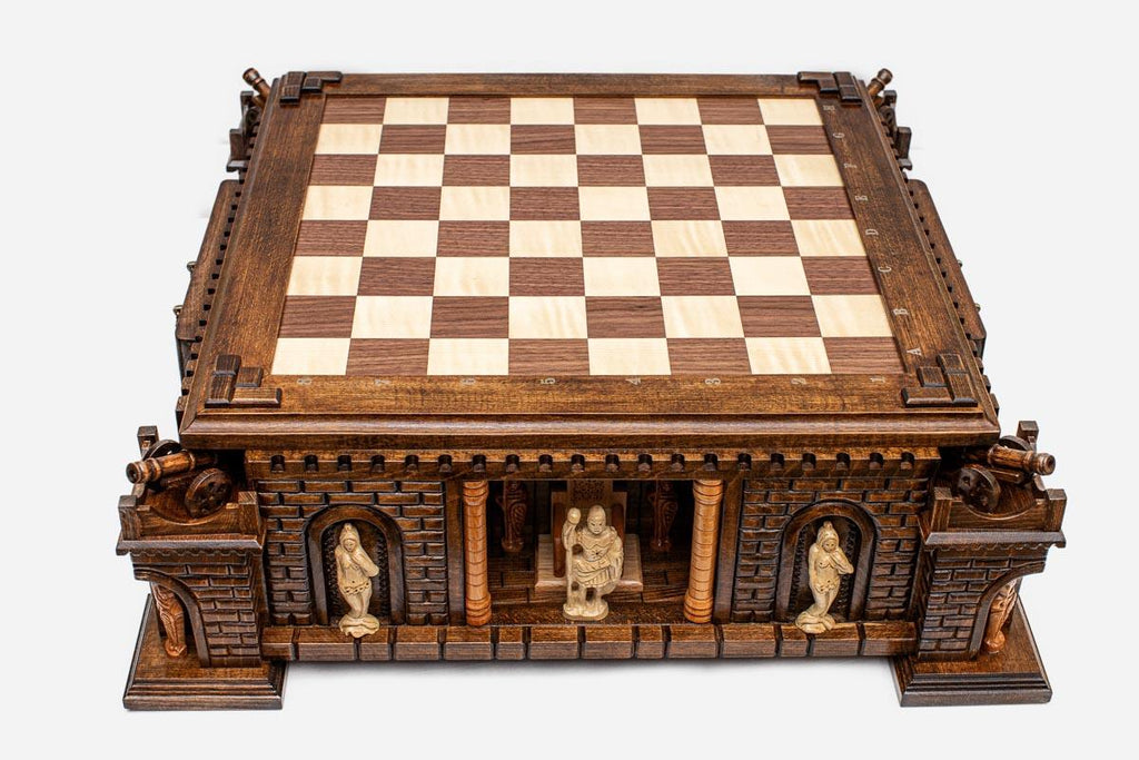 Front view of the castle chess board with carved sentinel figures standing in the arched niches of the fortress base