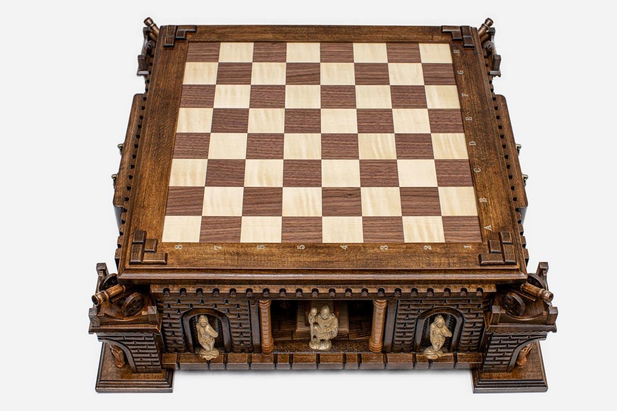 Top angle of the walnut and maple inlaid board raised on the hand-carved castle base