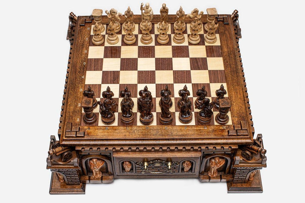 Angled view of the castle chess set fully set up with figural pieces and an open storage drawer