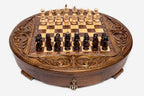 Angled view of the round carved chess set with dark and light wooden pieces arranged on the board