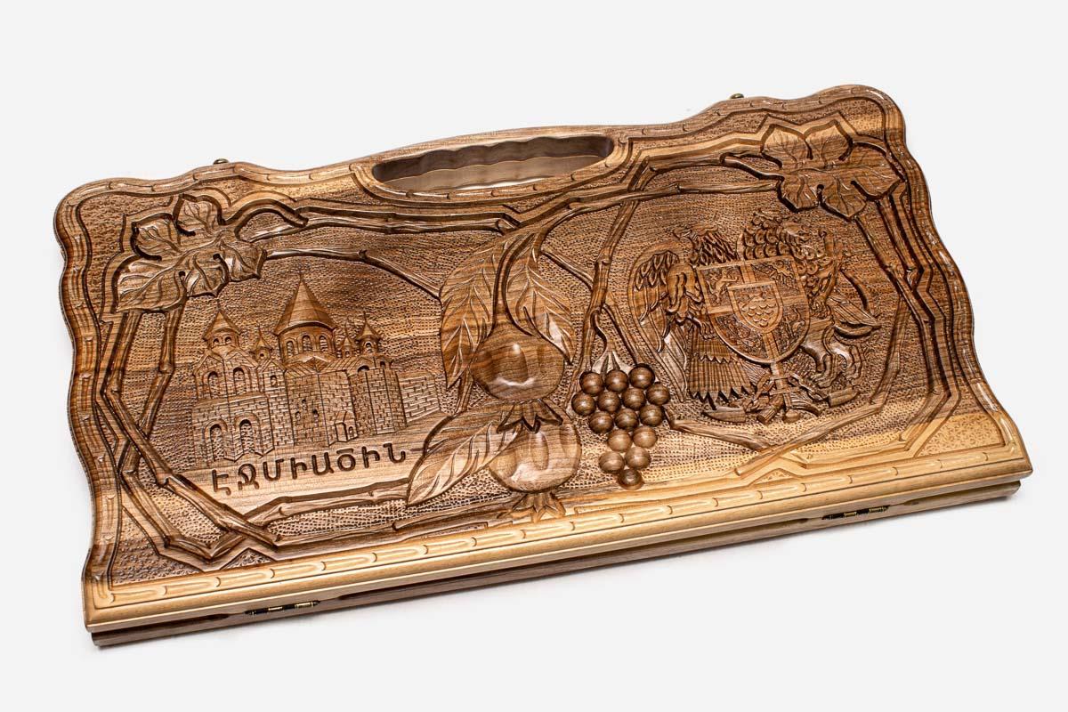 Angled view of the four scenes carved walnut backgammon board