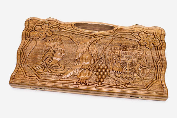 Carved walnut backgammon board with two carved scenes and a carry handle, propped open