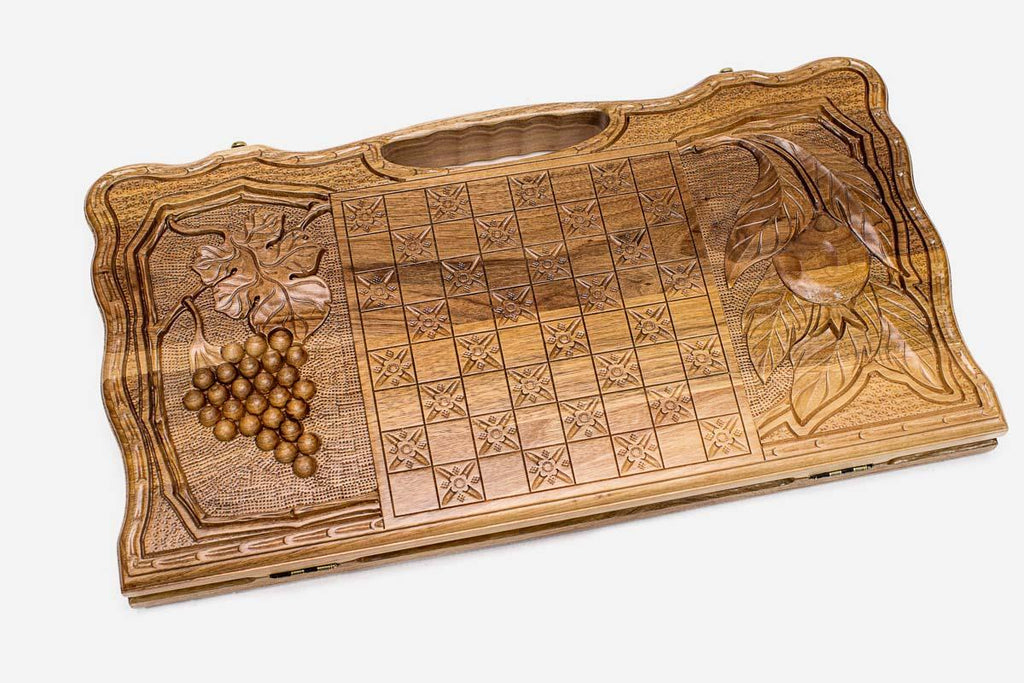 Angled view of the two scenes carved walnut backgammon board