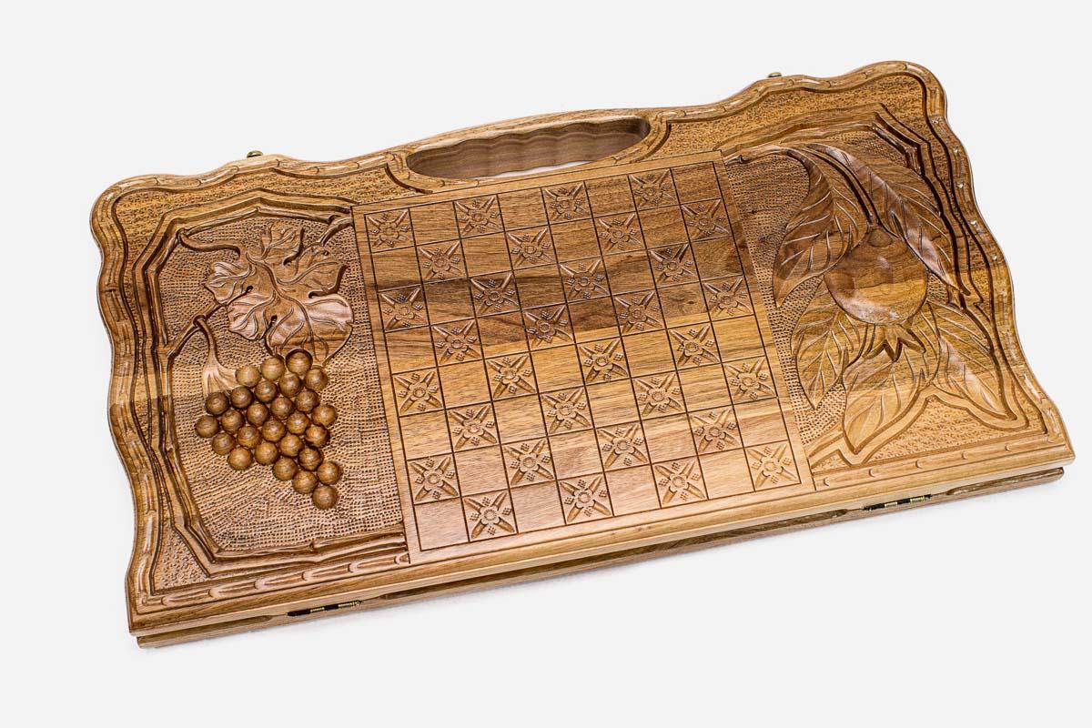 Angled view of the two scenes carved walnut backgammon board