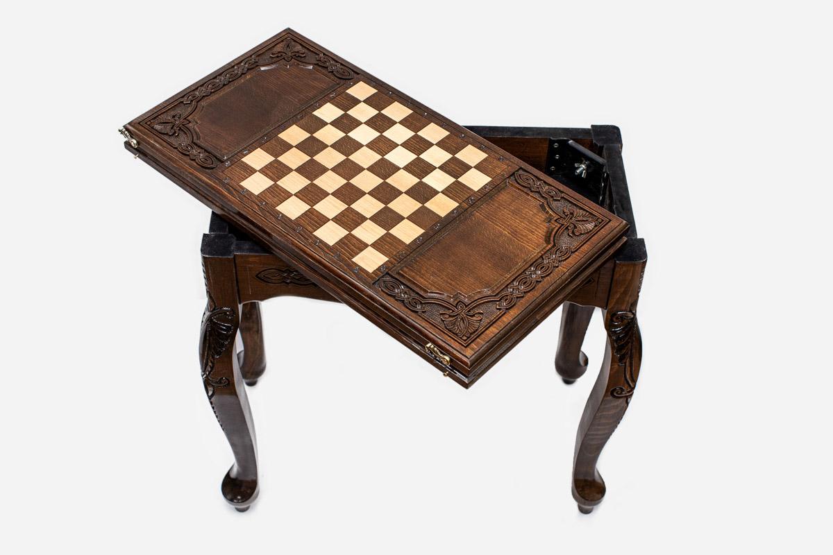Scalloped chess and backgammon table with chess pieces set up, angled view