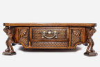Close-up of the Atlant chess set base showing the carved Atlas-figure legs and central drawer