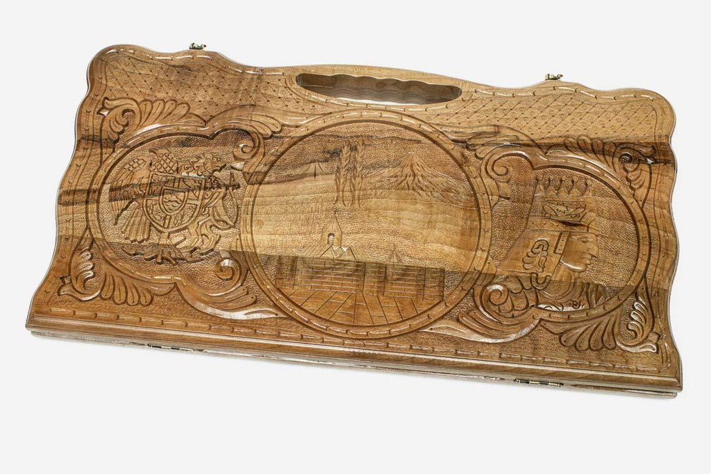 Carved walnut backgammon board with three carved scenes and a carry handle, propped open
