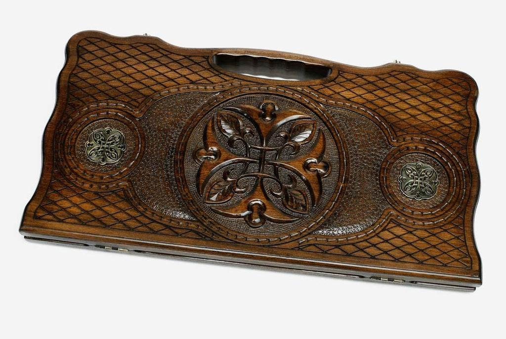 Carved beechwood backgammon board with a central carved ornament and bronze discs, propped open