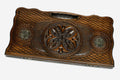 Carved beechwood backgammon board with a central carved ornament and bronze discs, propped open