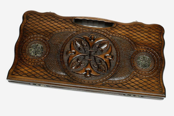 Carved beechwood backgammon board with a central carved ornament and bronze discs, propped open