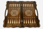Figural bronze chess pieces standing on the carved board
