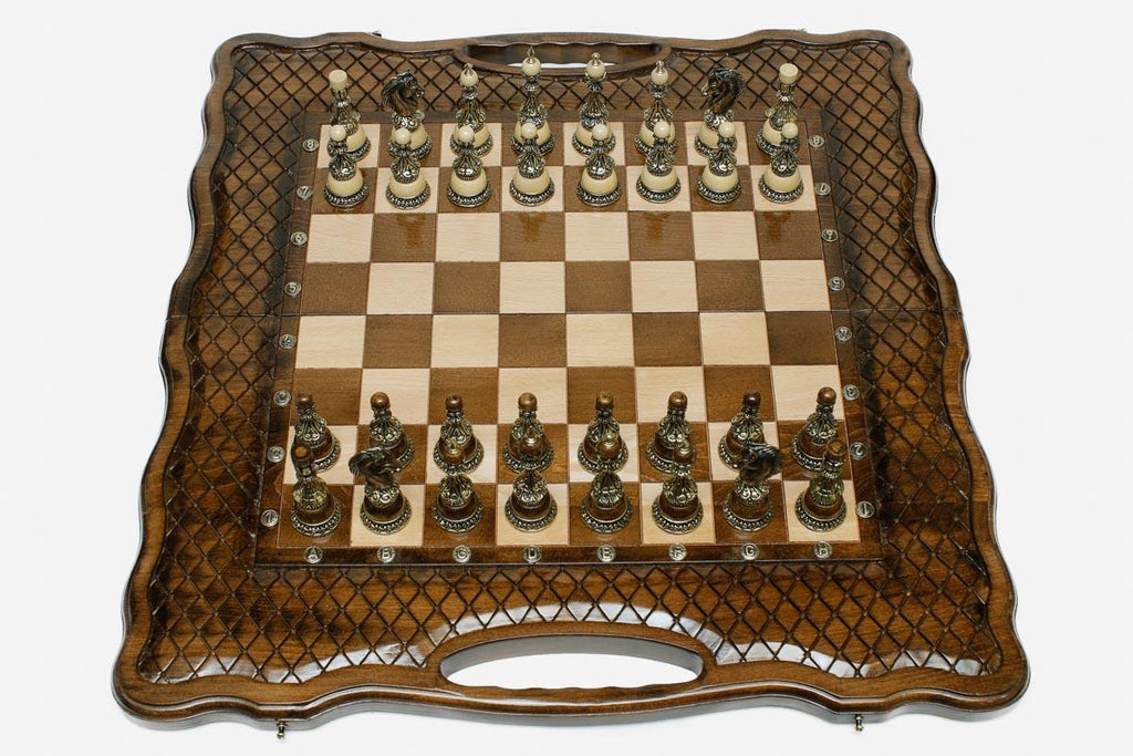 Luxury chess set with bronze pieces over carved diamond ornament