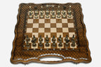 Luxury chess set with bronze pieces over carved diamond ornament