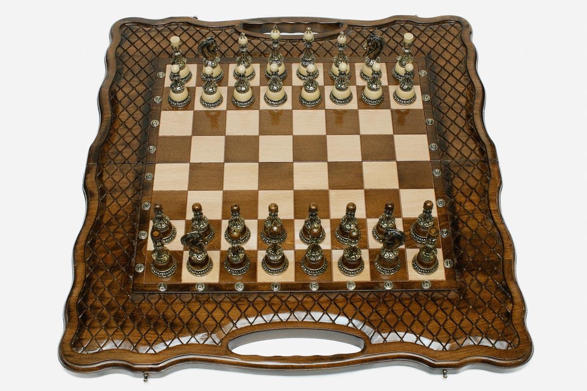 Luxury chess set with bronze pieces over carved diamond ornament