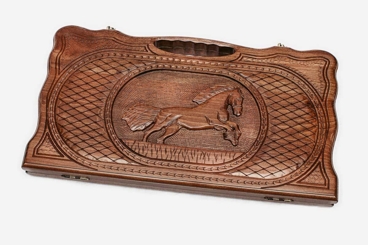 Carved walnut backgammon board with a horse at its center and a carry handle, propped open