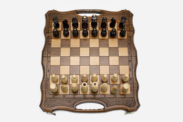 Classic walnut travel chess set with a carved lattice border and built-in carry handle, pieces in starting position