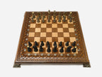 Figural bronze chess pieces on turned bases on the wooden board