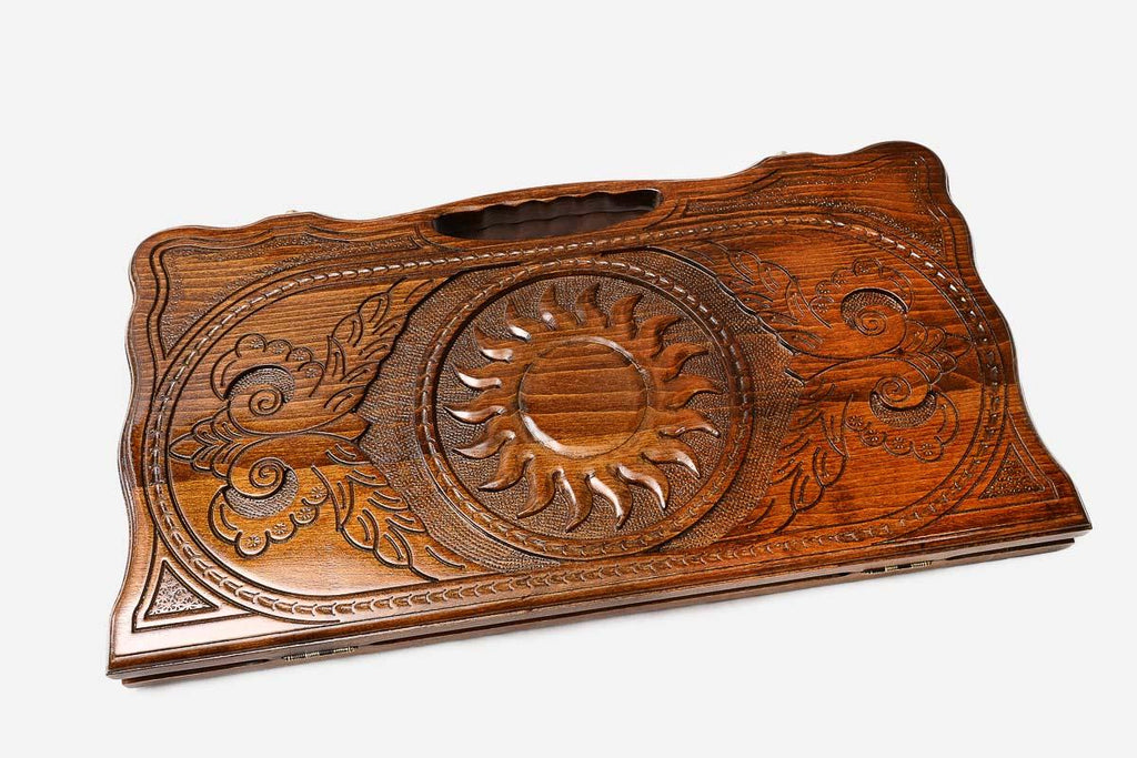 Angled view of the peacock and sun carved backgammon board