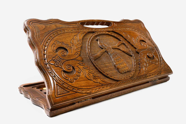 Carved beechwood backgammon board with a peacock and radiant sun and a carry handle, propped open