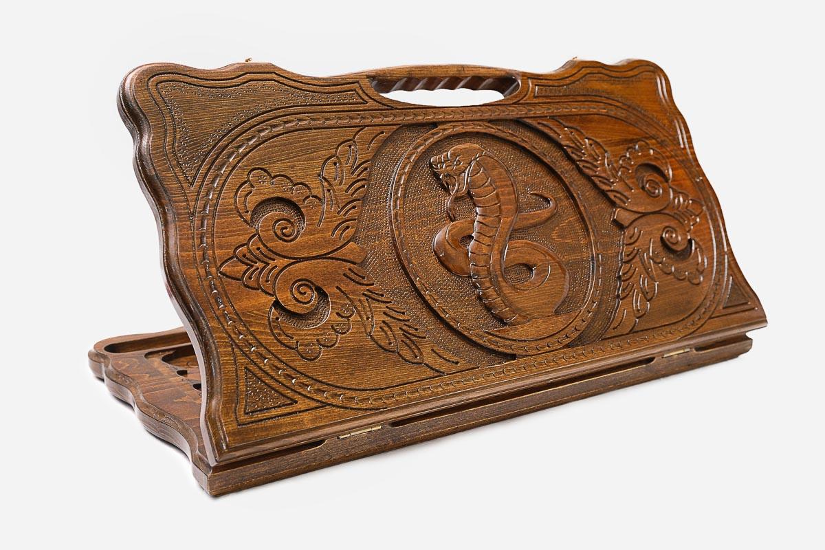 Carved beechwood backgammon board with twin serpents around a floral ornament, propped open
