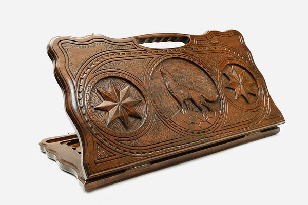 Carved beechwood backgammon board with a wolf between carved stars, propped open