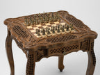 Close-up of the chessboard with bronze pieces on the wooden table