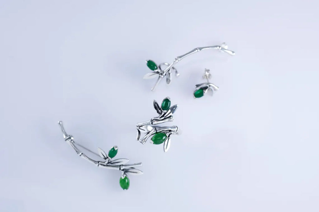 Minimalist sterling silver ear crawler with bamboo design and green accent