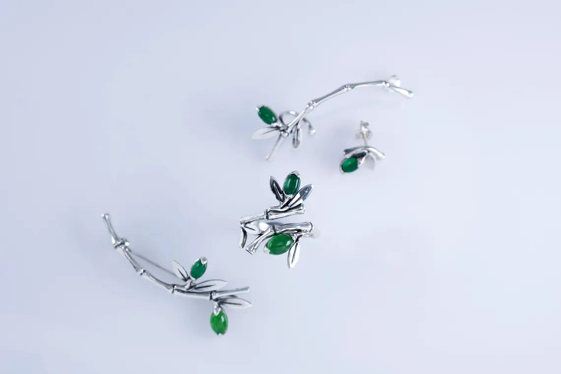 Minimalist sterling silver ear crawler with bamboo design and green accent