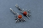 Silver earrings with red stones on a gray background