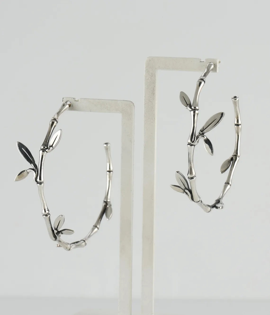 Silver branch-shaped earrings on a white background