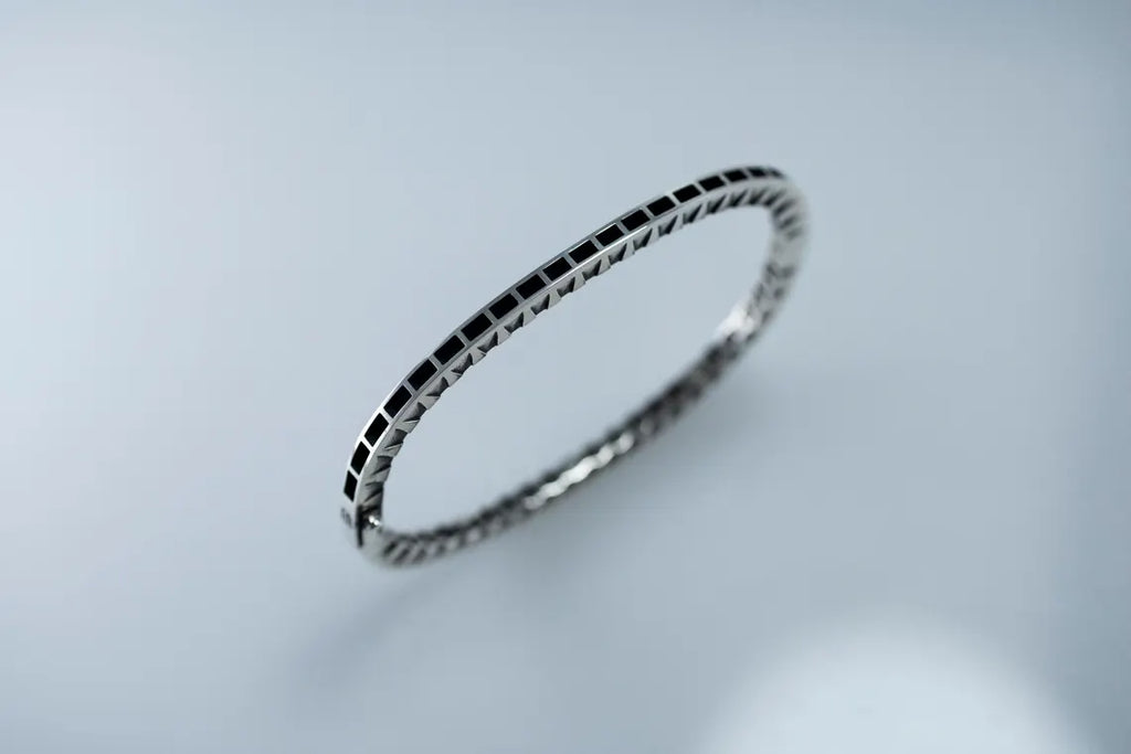 Silver bracelet on a light gray background