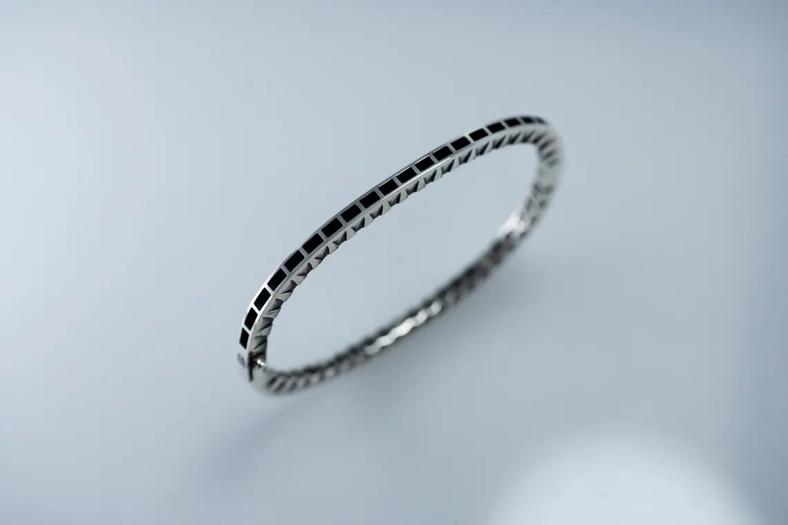 Silver bracelet on a light gray background