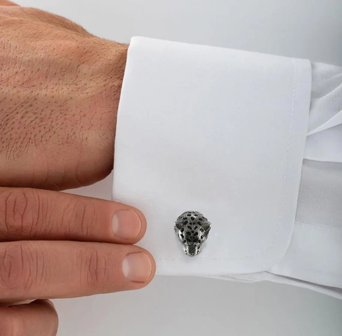 Cufflink shaped like a skull on a white shirt cuff