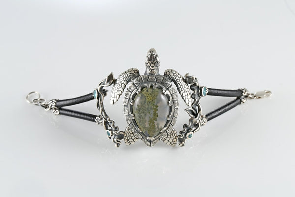 Silver bracelet with a central stone on a white background