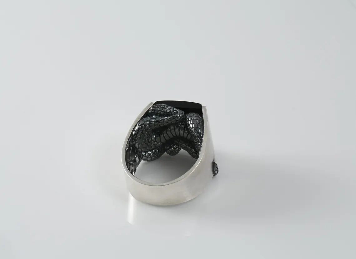 Silver ring with black pattern on a white background