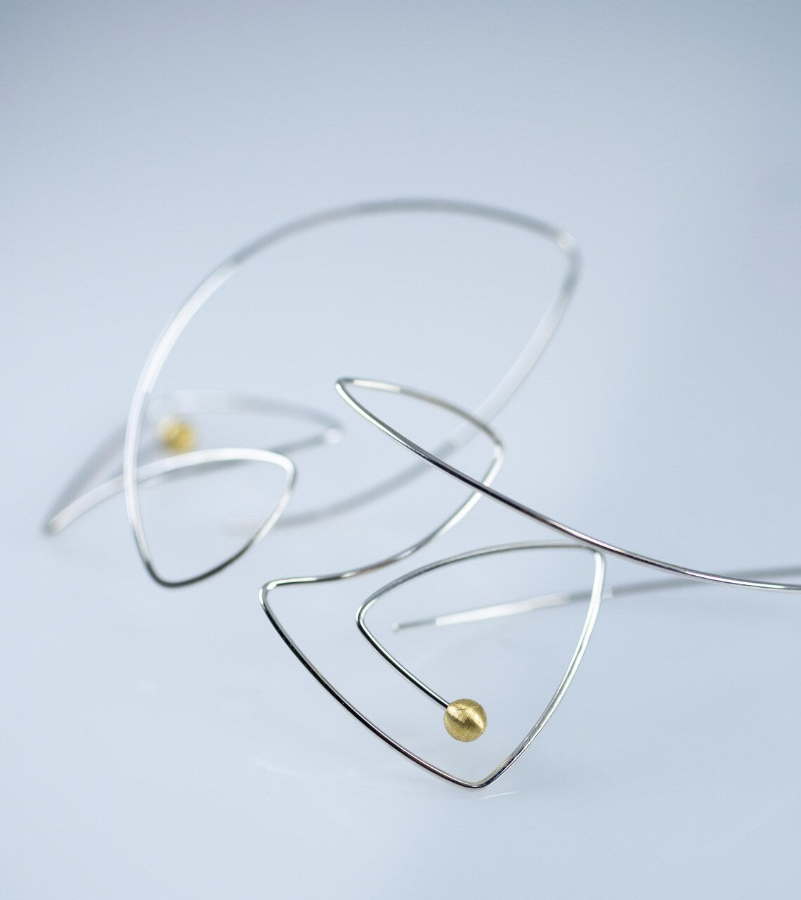 Minimalist fish-shaped dangle earrings made from sterling silver