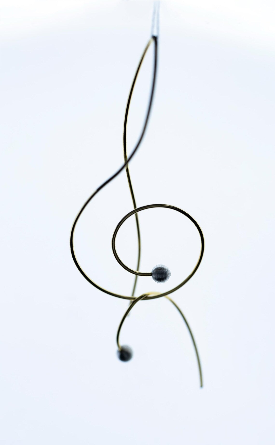 Decorative metal treble clef on a white background