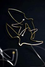 Bird and pearl artisan earrings close-up