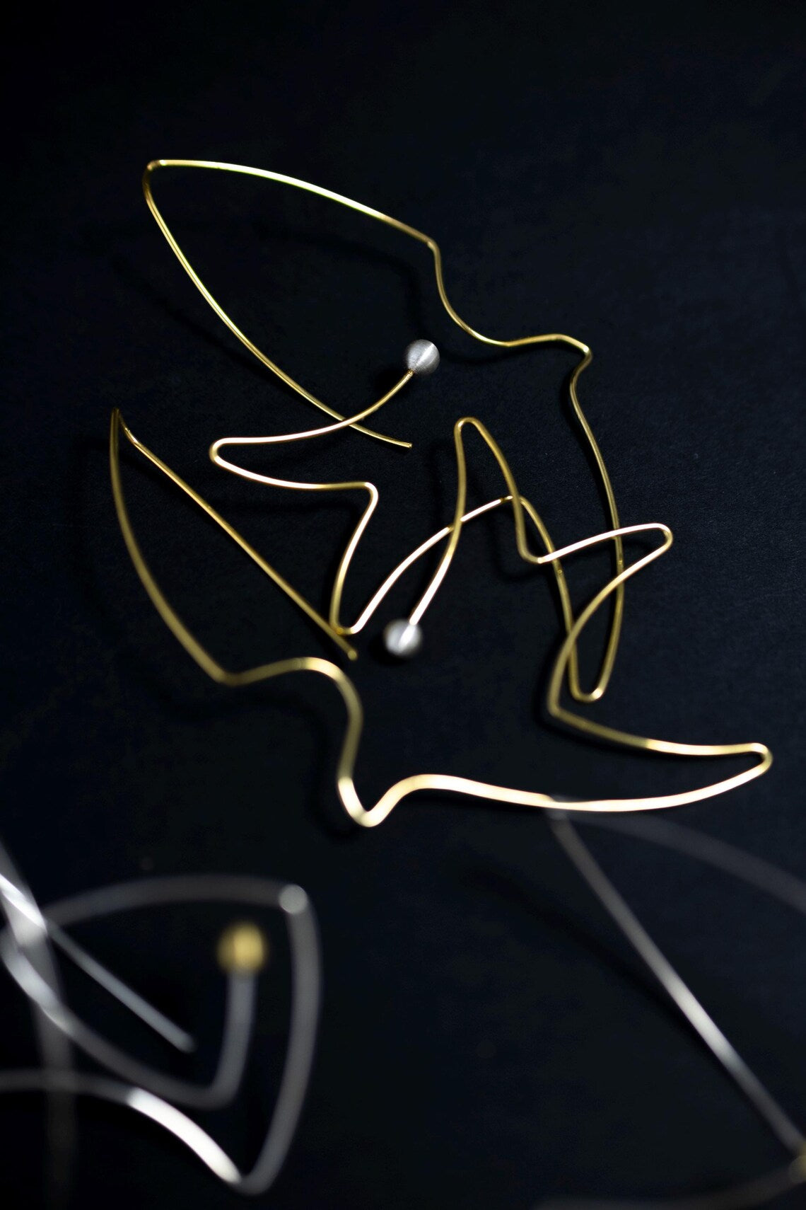 Bird and pearl artisan earrings close-up