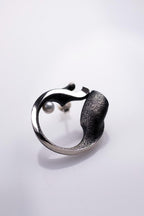 Silver ring with a textured band on a light gray background