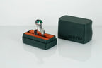 Silver ring with green gemstone in a black box on a white background