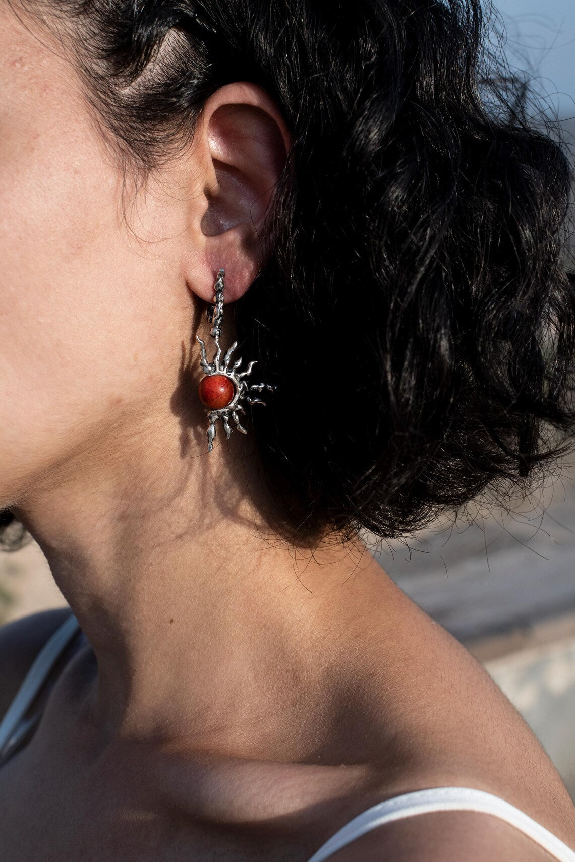Artistic dangle earrings shaped like rising sun in silver