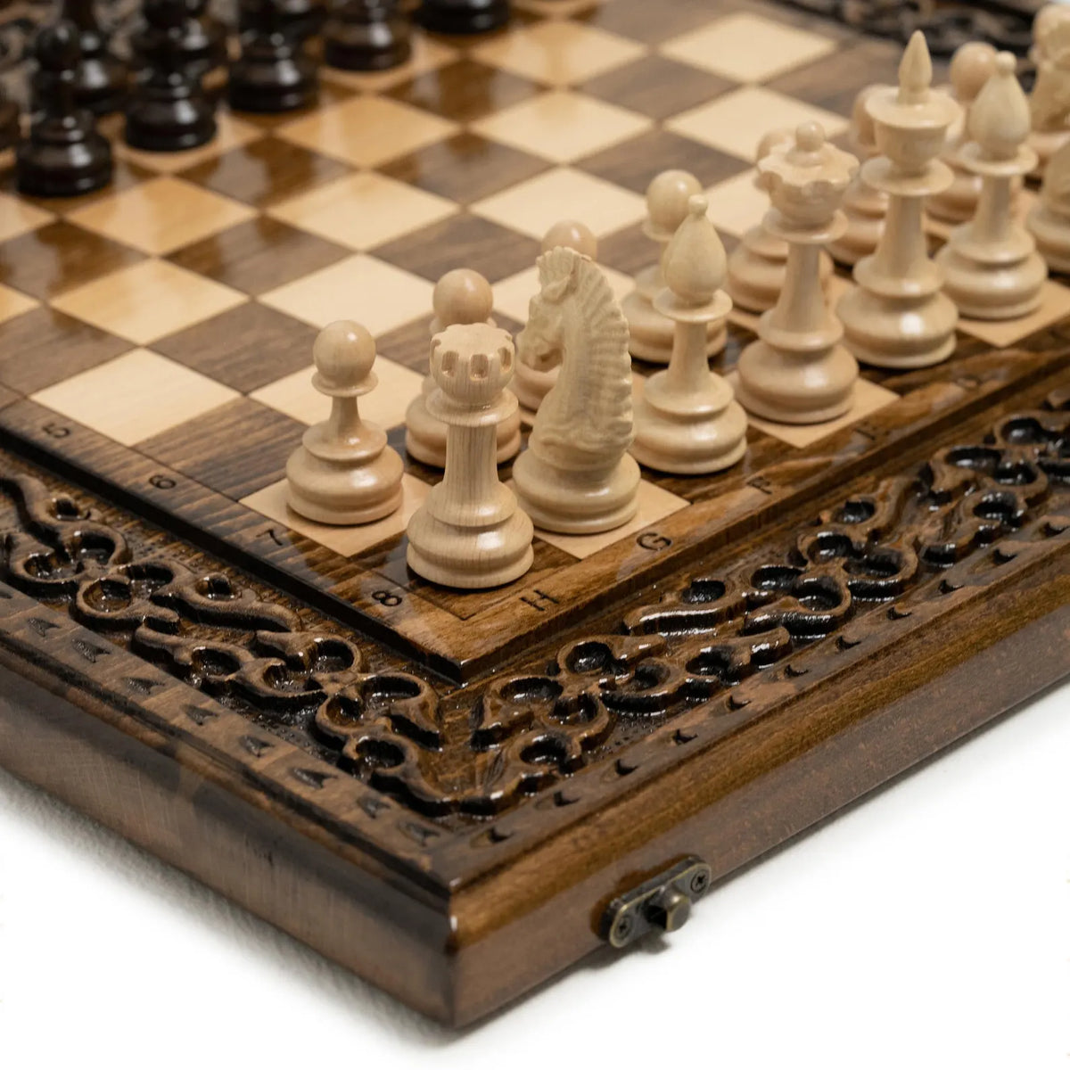 Hand-carved wooden chess pieces on the ornament board