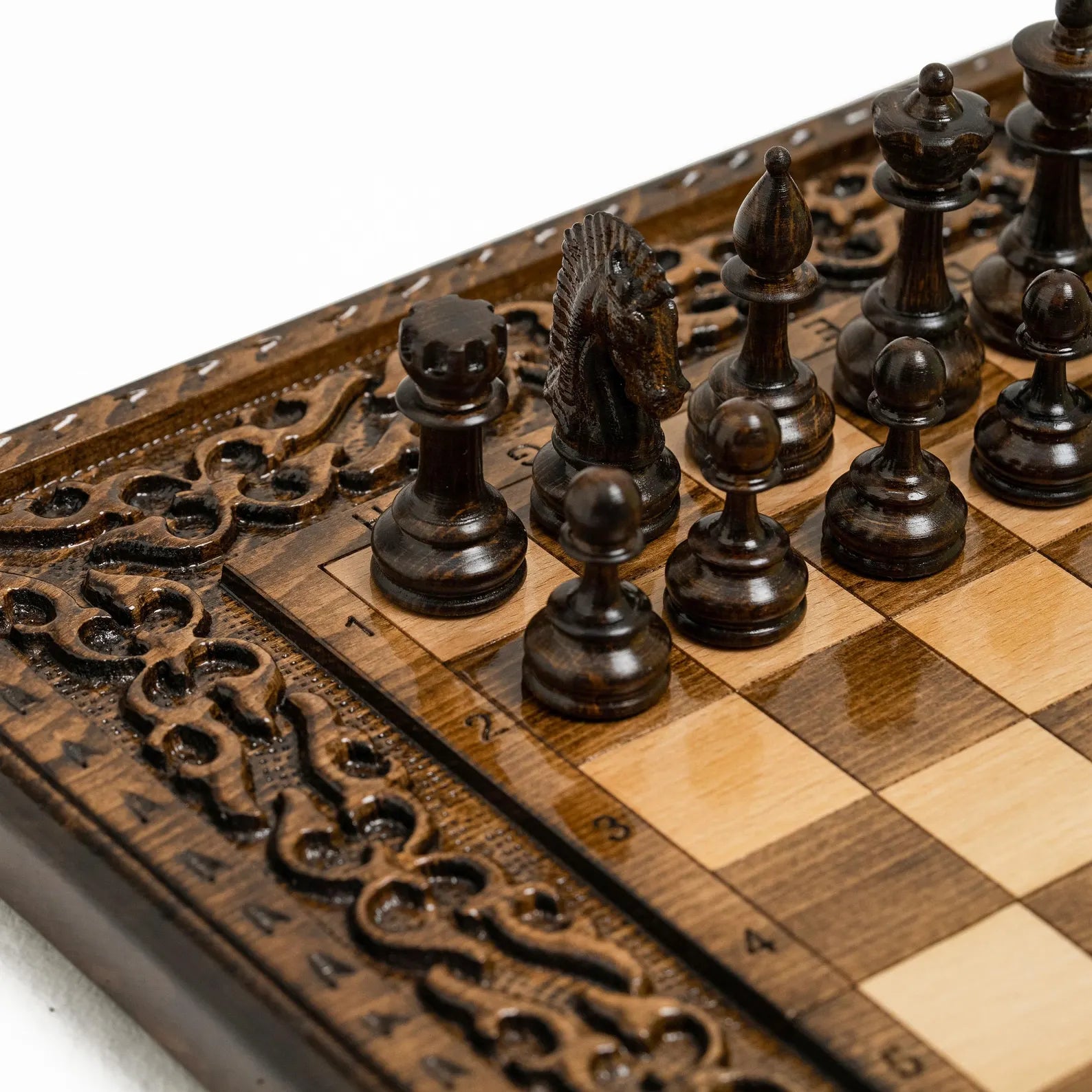 Ornament-carved wooden chessboard surface close-up