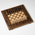 Carved wooden chess set with grapevine motif, angled view